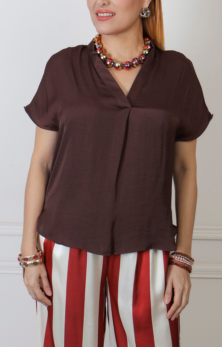 Blusa de manga corta con escote en V de la marca Boutiquemirel, estilo regular, en tela lisa de color neutro.