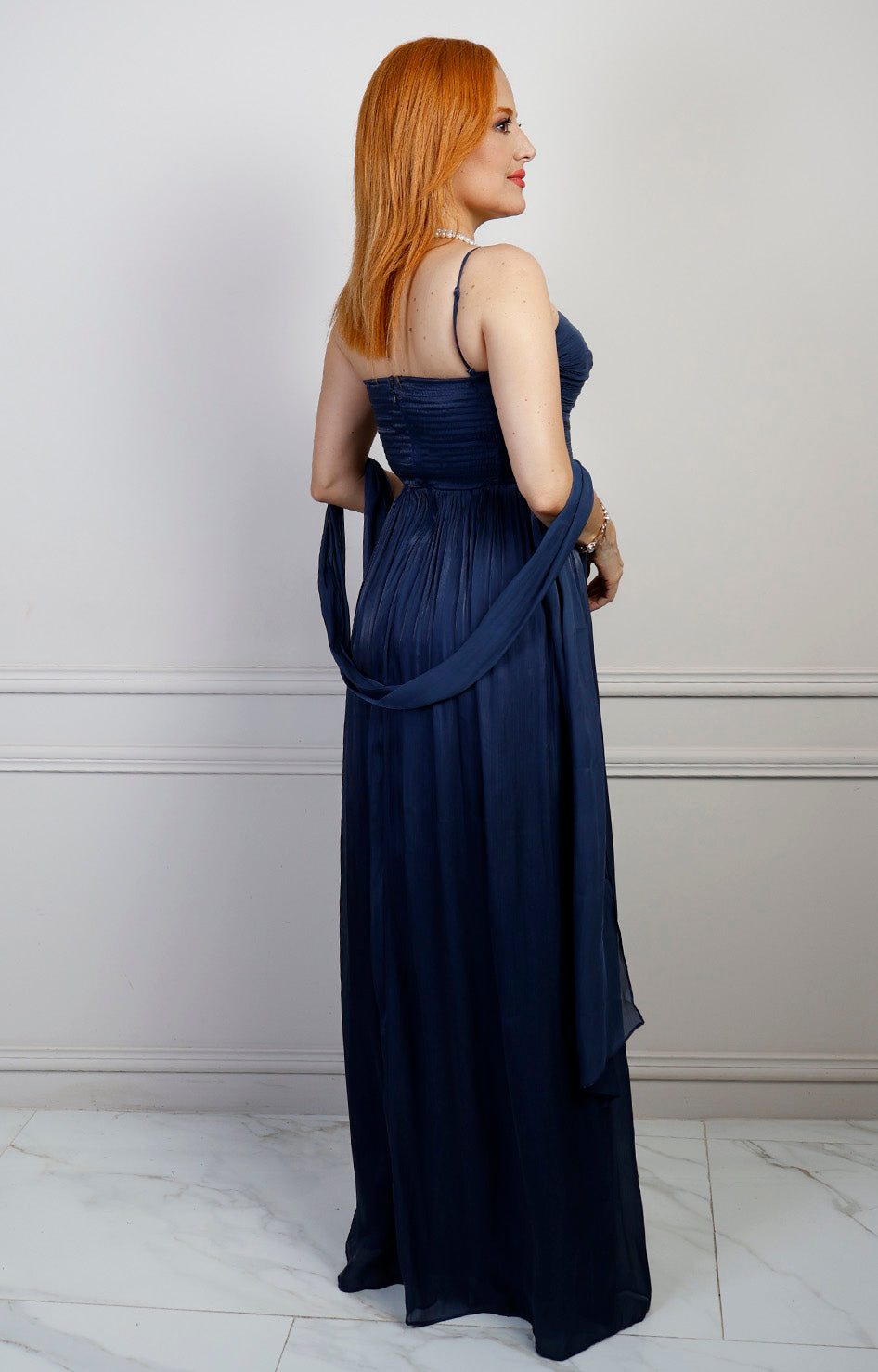 Vestido largo strapless de Boutiquemirel, con diseño drapeado y estilo elegante, muestra la parte superior y caída del vestido.