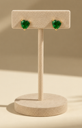 Aretes de corazón verde Boutiquemirel, diseño colgante con acabado brillante y detalle central.