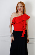 Blusa roja asimétrica con olanes de la marca Boutiquemirel, de estilo regular, mostrando la tela y detalles de los olanes.