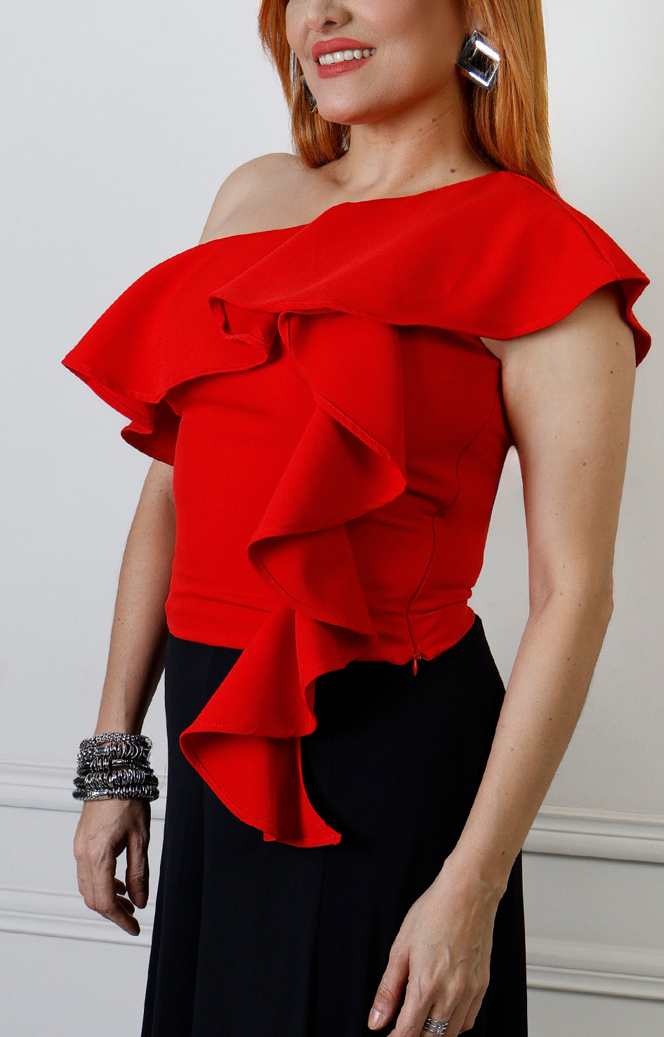Blusa roja asimétrica con olanes de la marca Boutiquemirel, estilo regular, mostrada en la imagen con detalles en el diseño.