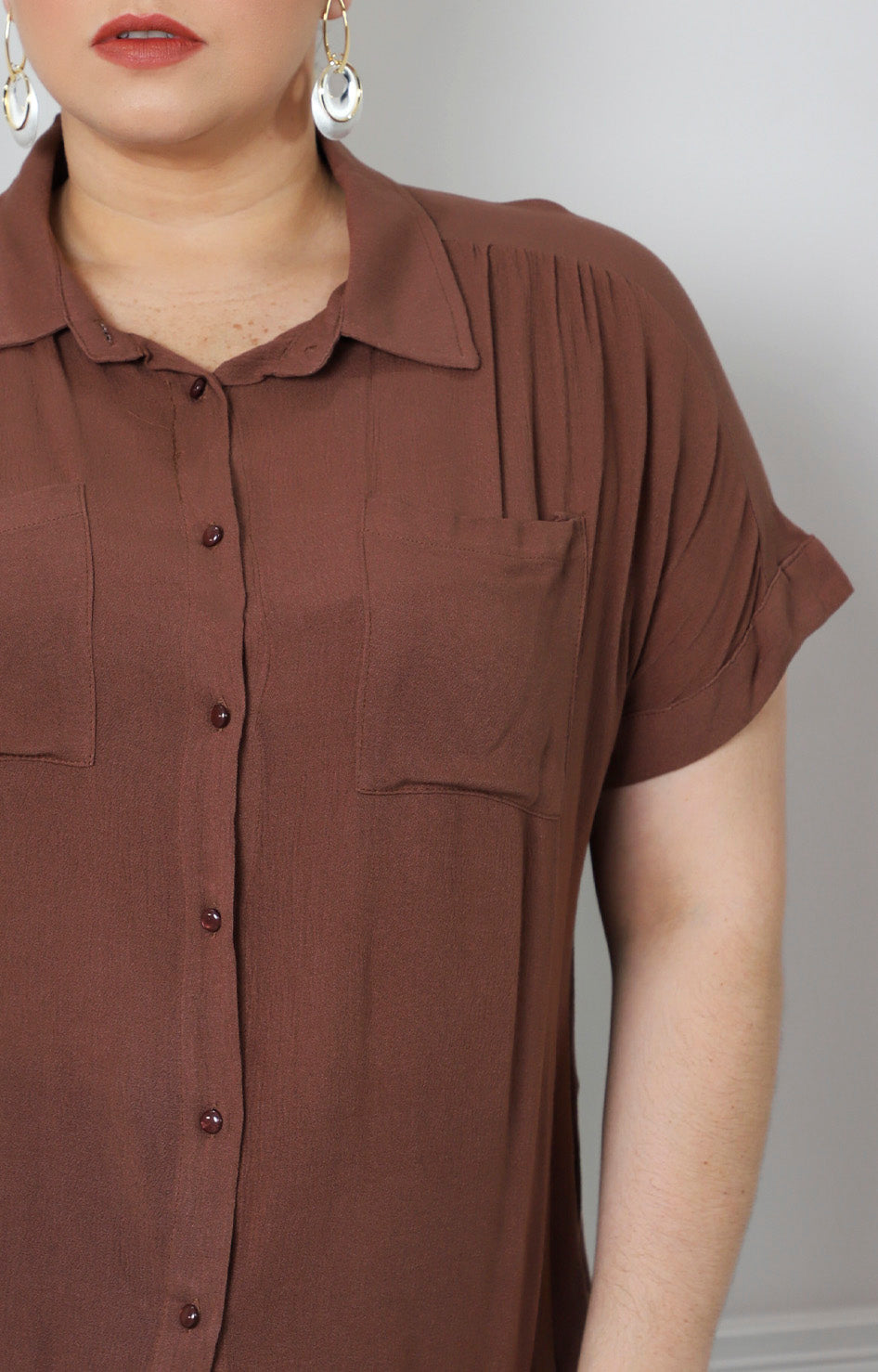 Blusa café con bolsillos frontales