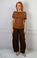 Blusa regular de Boutiquemirel con escote drapeado y detalle dorado, tela suave y diseño elegante visible en la imagen.