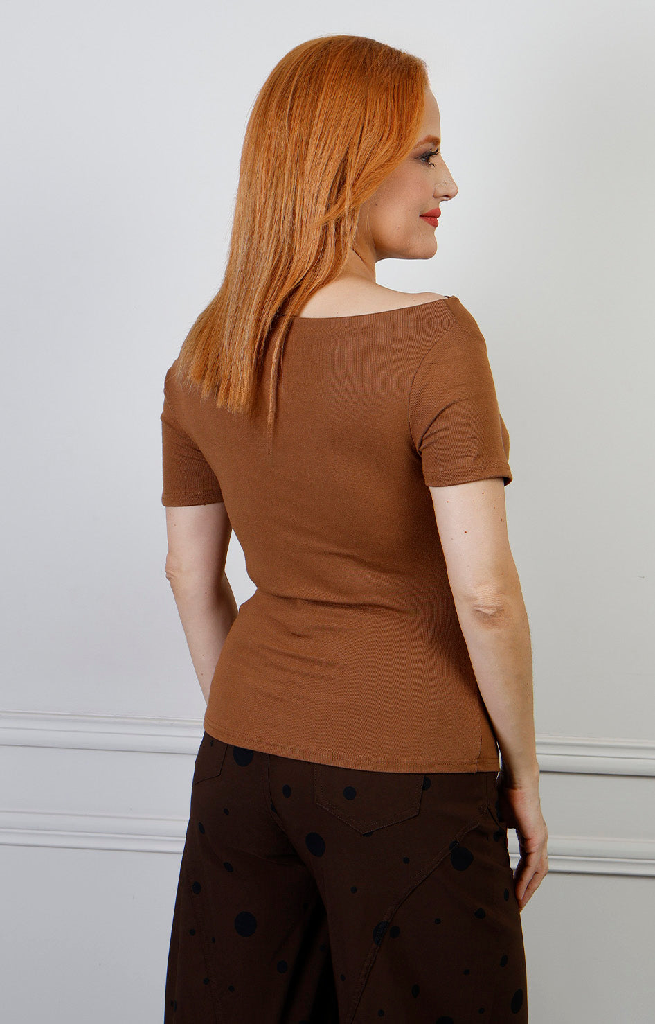 Blusa regular de Boutiquemirel con escote drapeado y detalle dorado, mostrando el diseño elegante y cómodo.