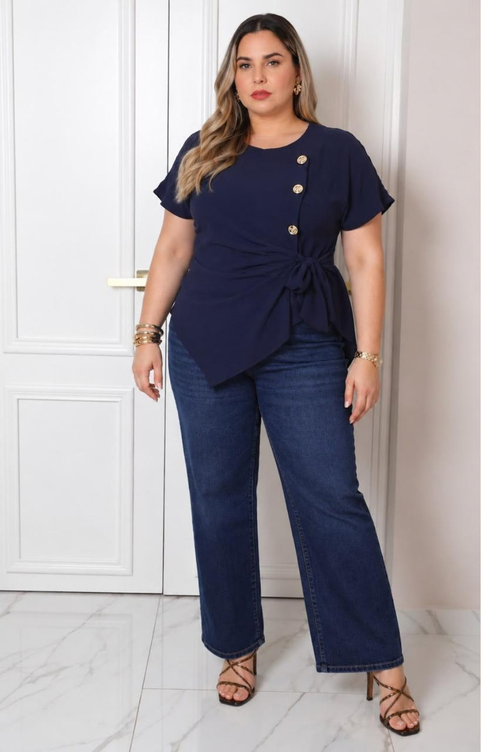 Blusa curveada Boutiquemirel con lazo y botones dorados, tela suave y elegante, vista frontal en color neutro