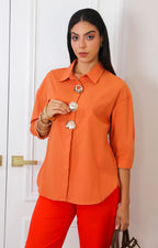 Blusa camisera naranja con botones dorados