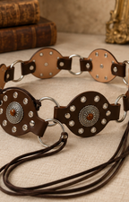 Cinturón de conchos metálicos Boutiquemirel con detalles decorativos visibles en la correa