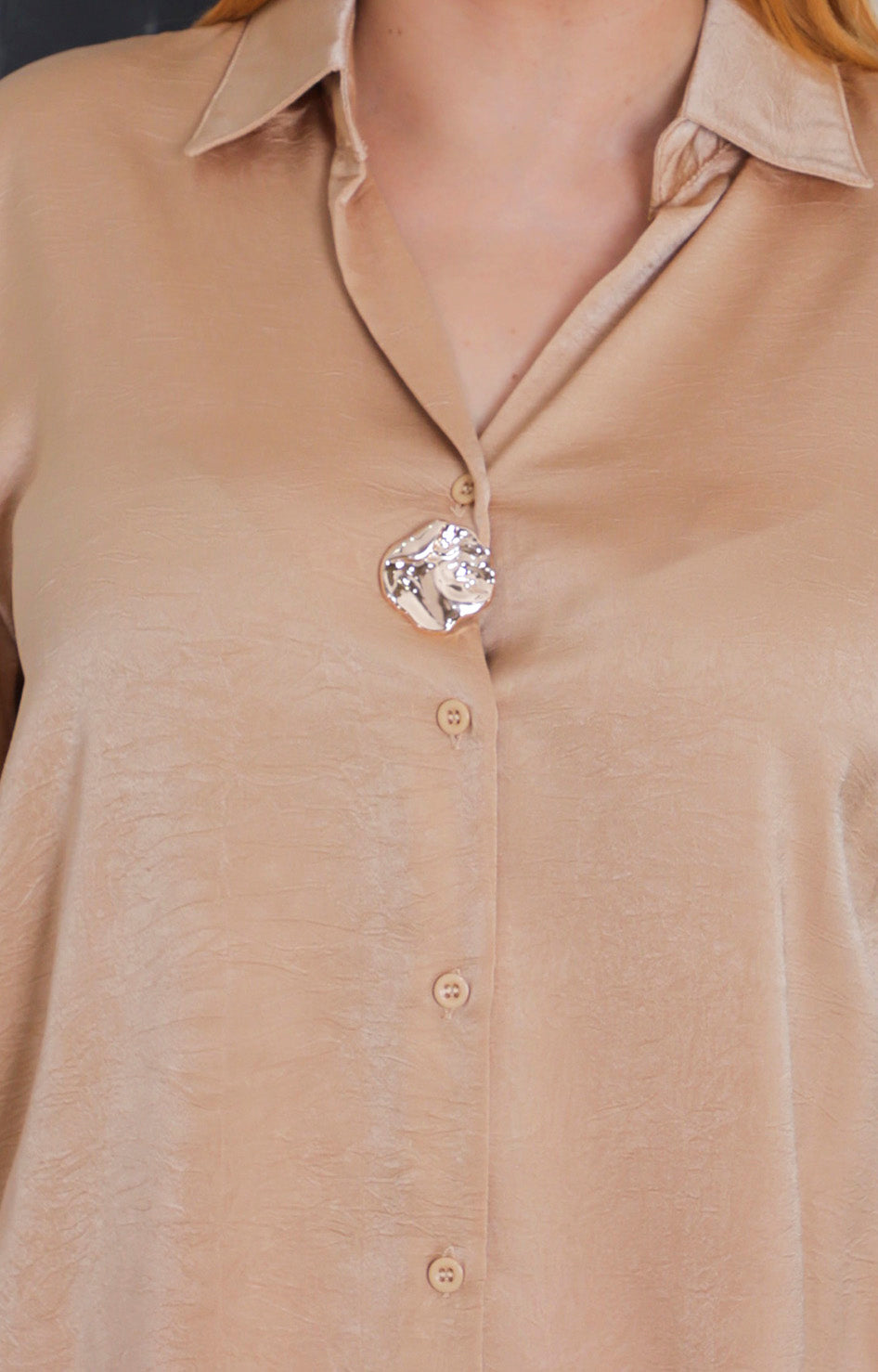 Blusa satinada con botón dorado