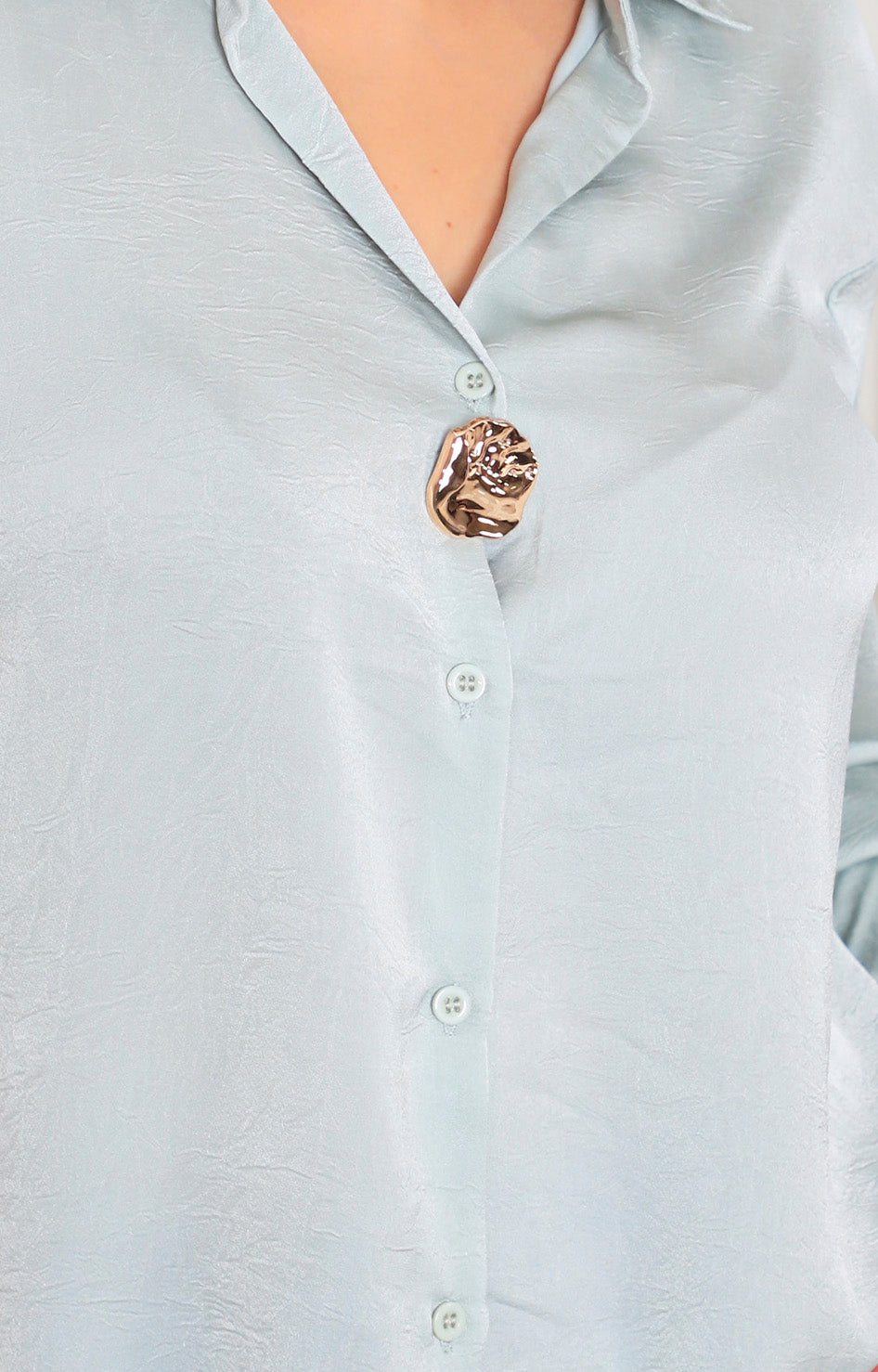 Blusa satinada con botón dorado