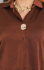 Blusa satinada con botón dorado