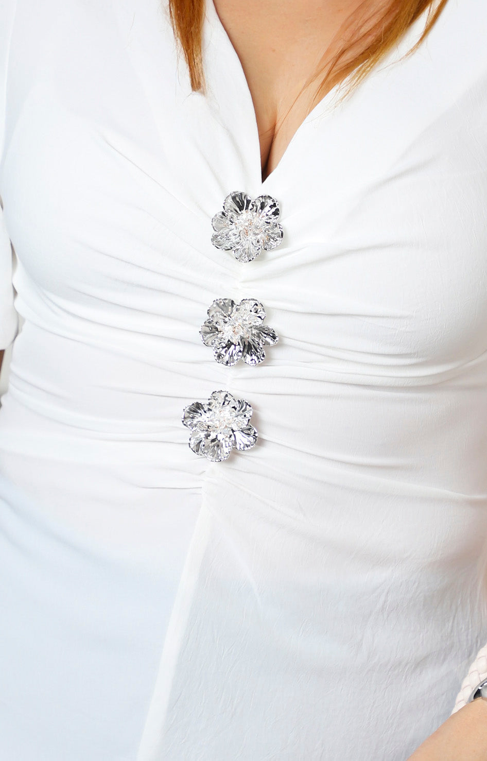 Blusa fruncida con broches de flor