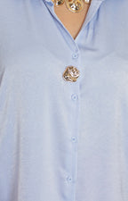 Blusa satinada con botón dorado
