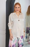 Blusa satinada con botón dorado