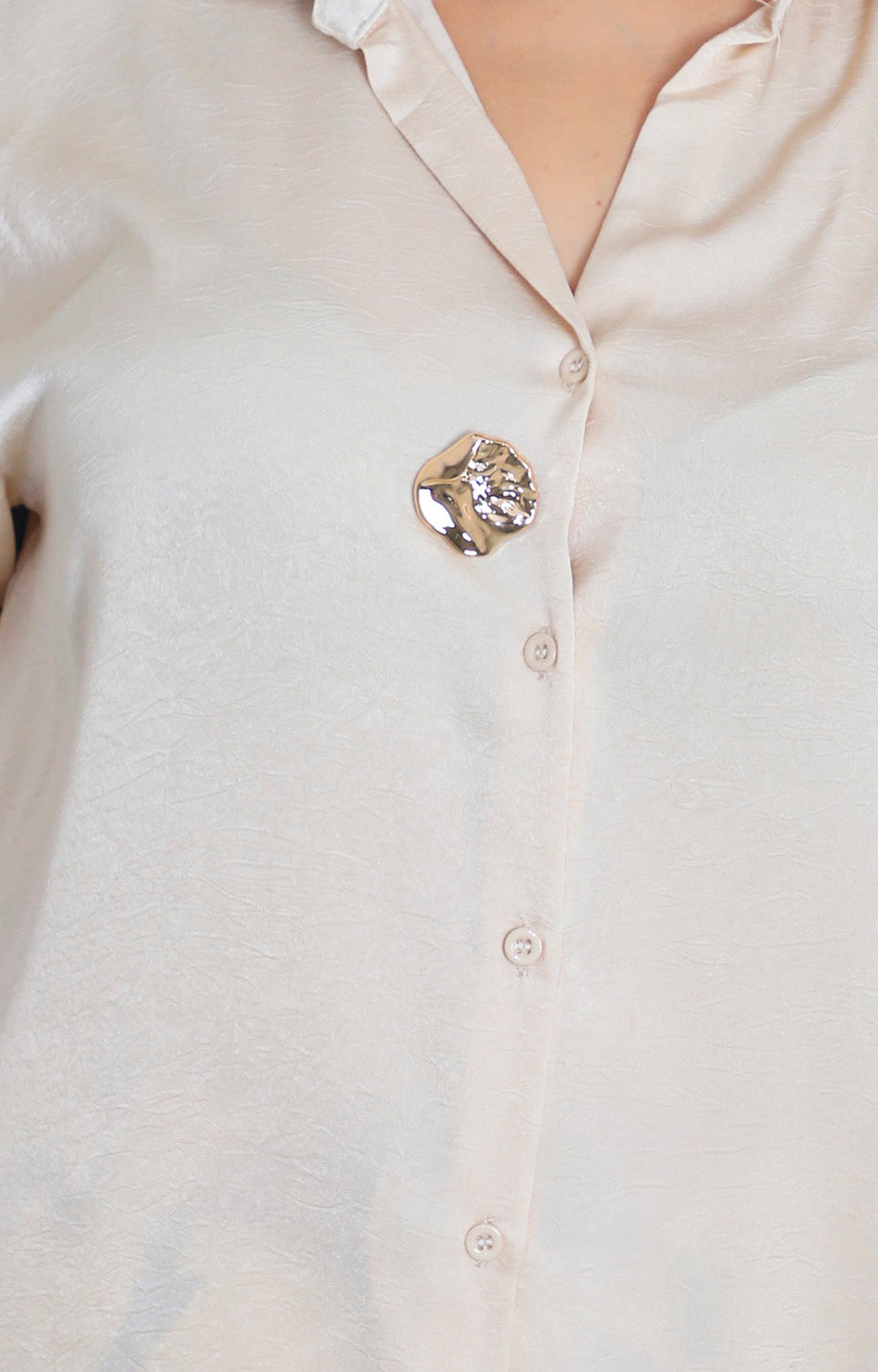 Blusa satinada con botón dorado