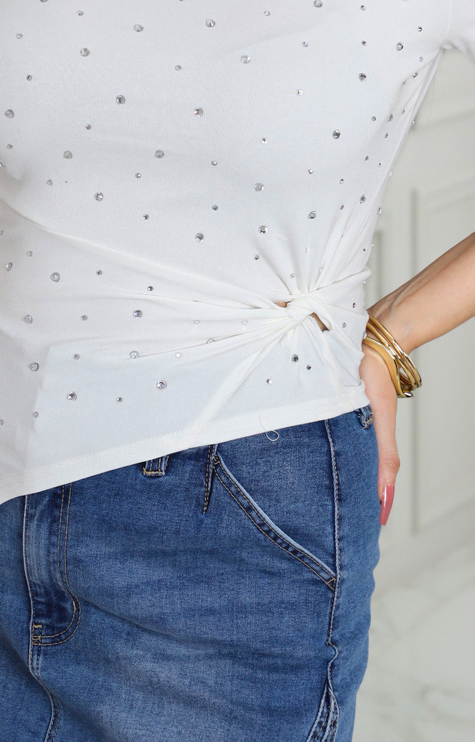 Blusa blanca asimétrica con pedrería y nudo