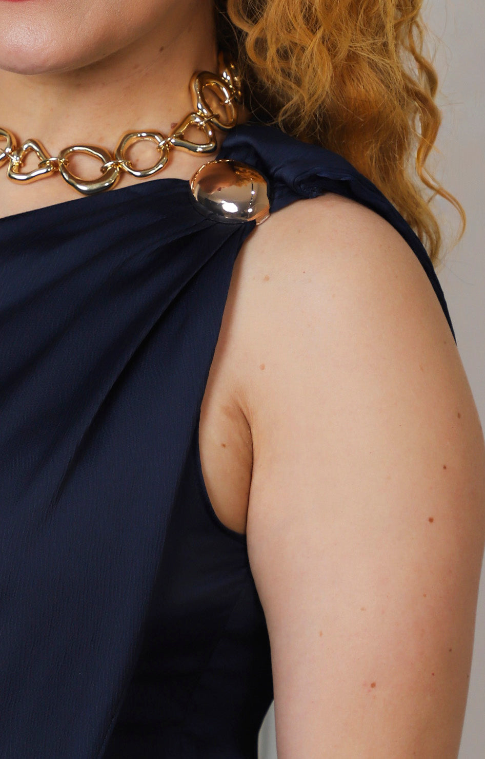 Blusa azul asimétrica con detalle dorado