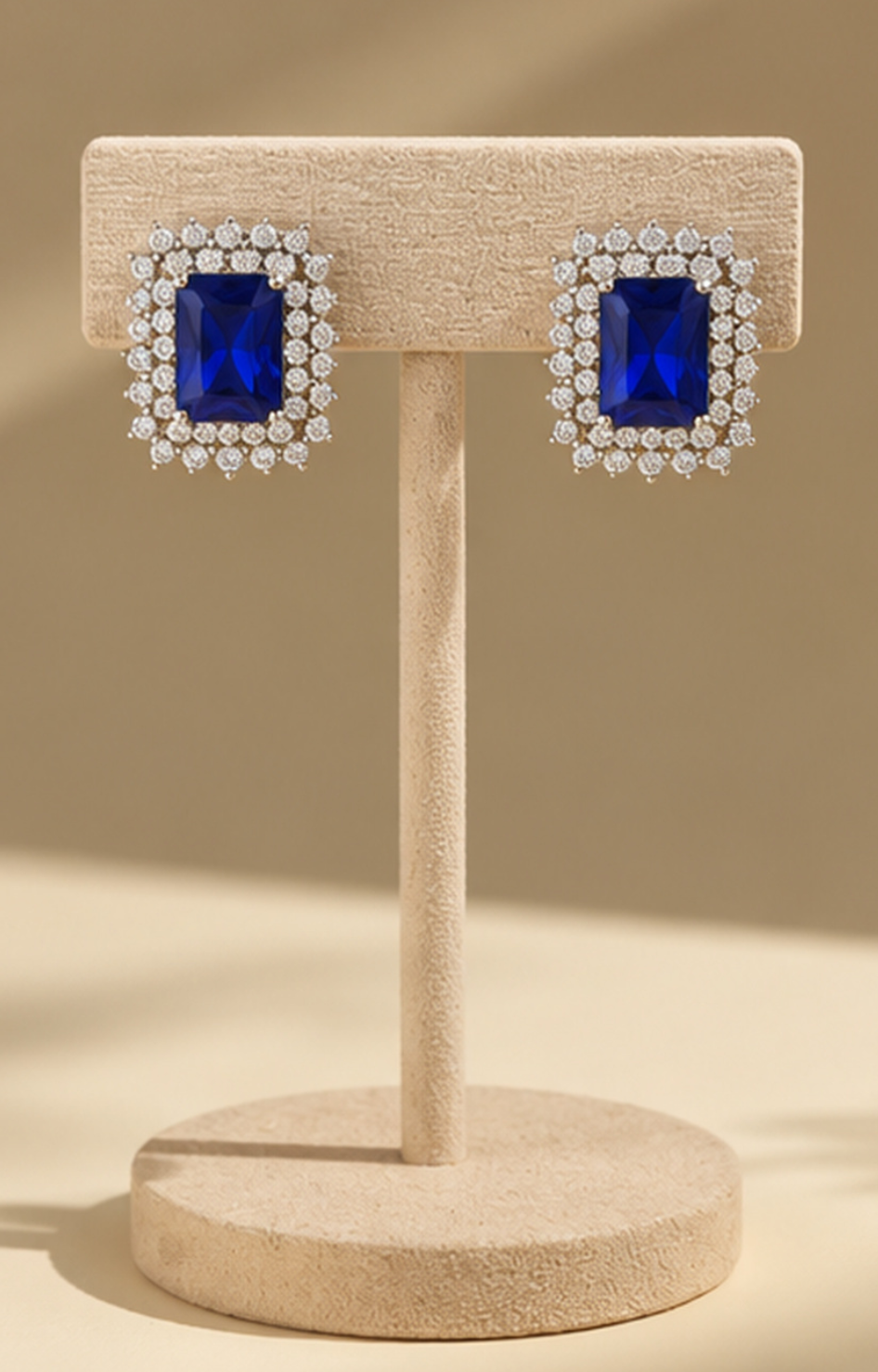 Aretes Boutiquemirel con piedra azul rectangular, diseño elegante y acabado metálico.