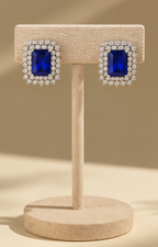 Aretes Boutiquemirel con piedra azul rectangular, diseño elegante y acabado metálico.