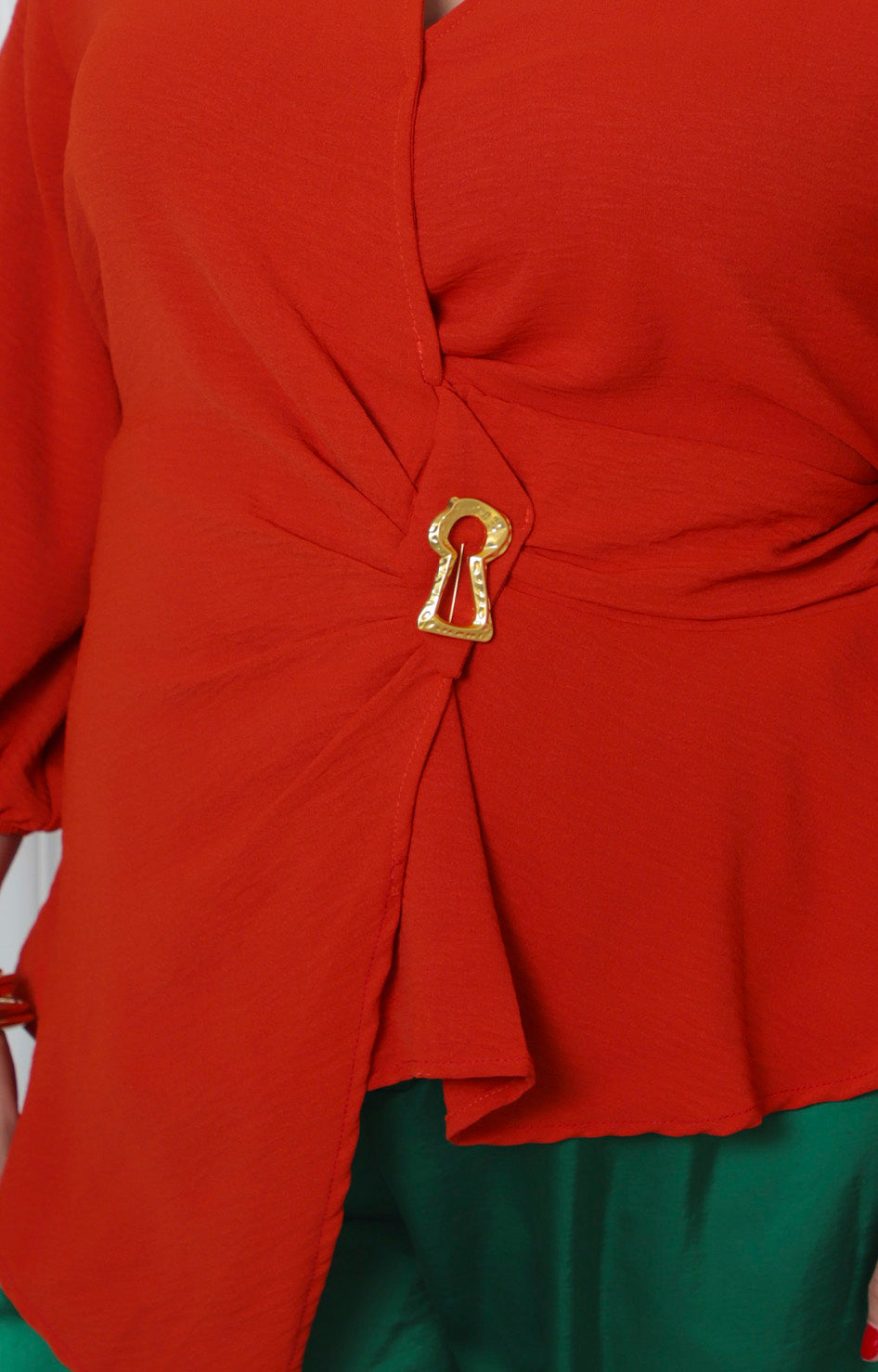 Blusa beige asimétrica para curvy de Boutiquemirel con detalle dorado y diseño elegante en la parte frontal.