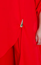 Conjunto rojo asimétrico con broche dorado
