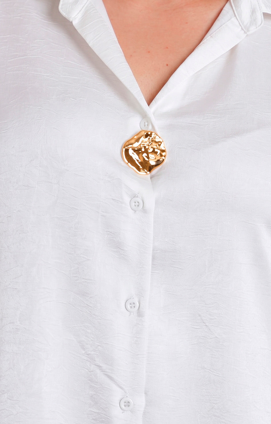 Blusa satinada con botón dorado