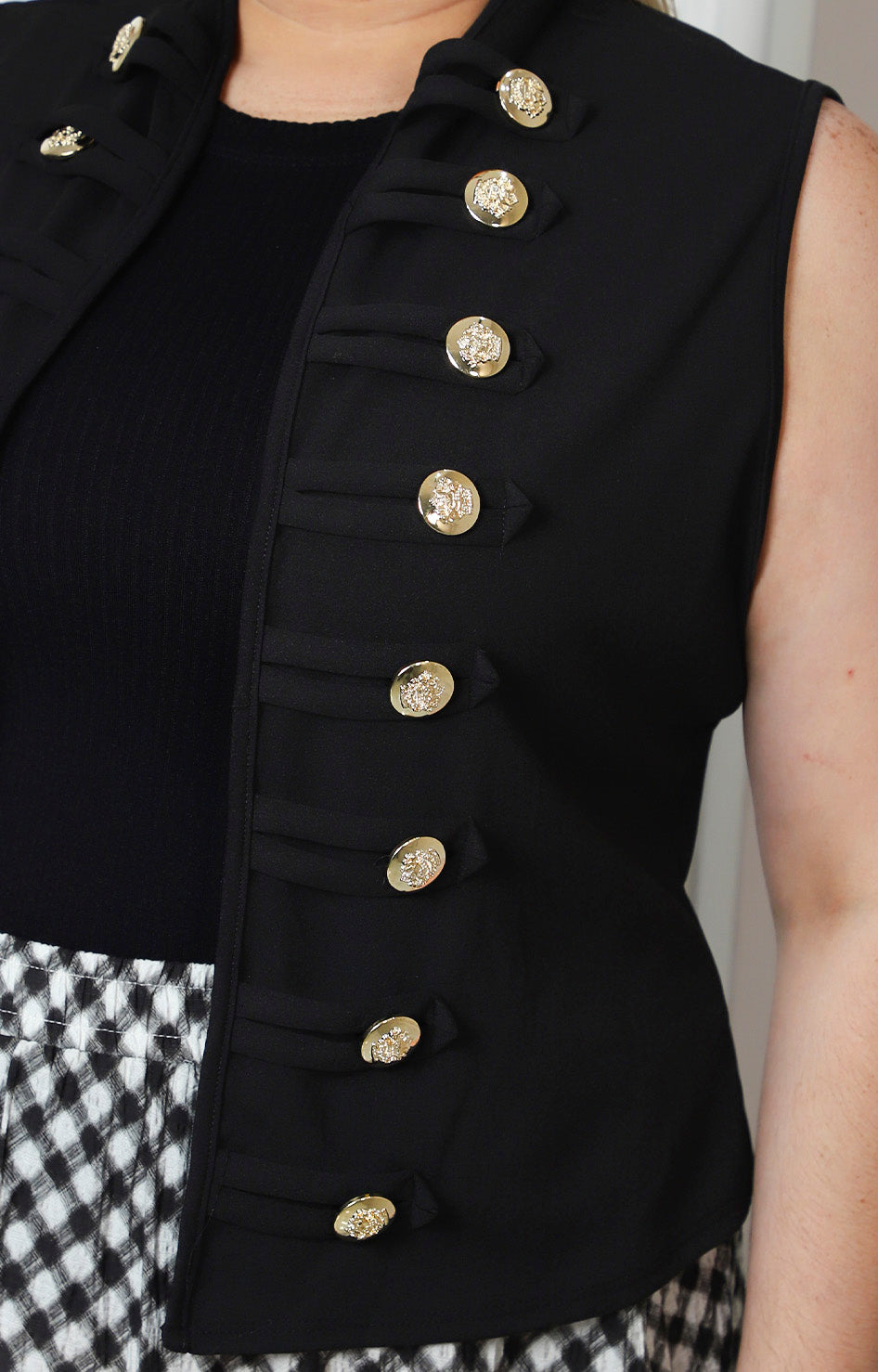 Chaleco negro estilo militar con botones dorados