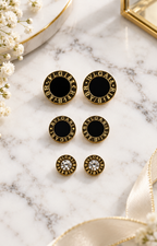 Set de aretes de broquel negro y dorado con cristal