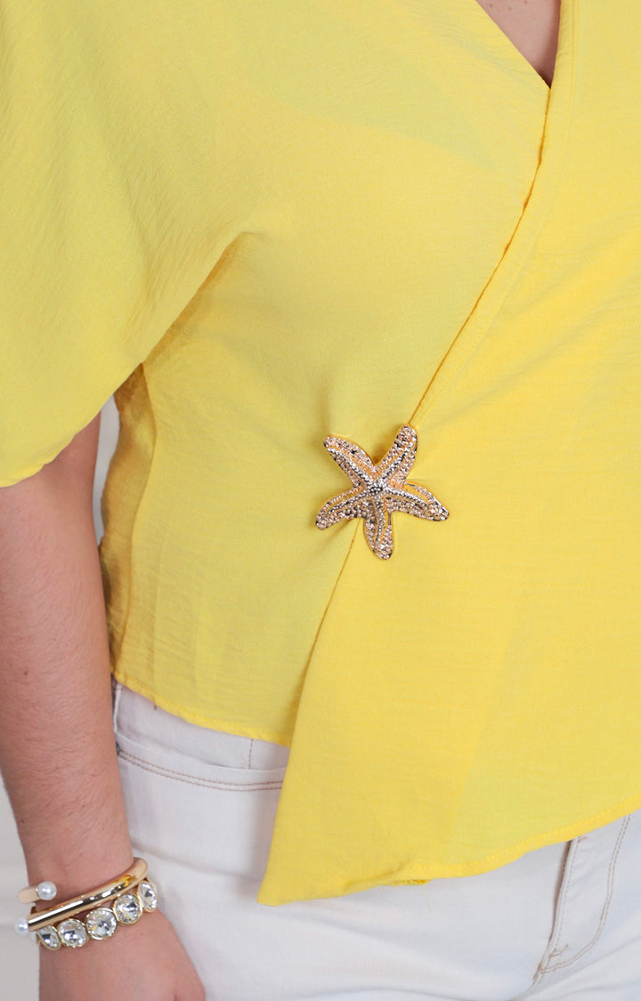 Blusa amarilla con broche de estrella
