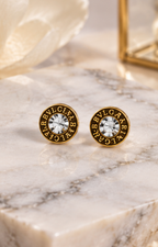 Set de aretes de broquel negro y dorado con cristal