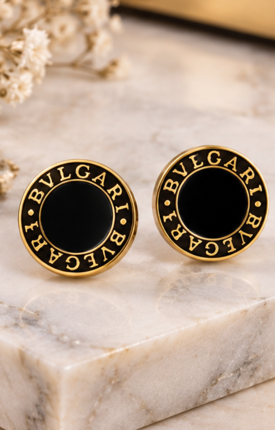 Set de aretes de broquel negro y dorado con cristal