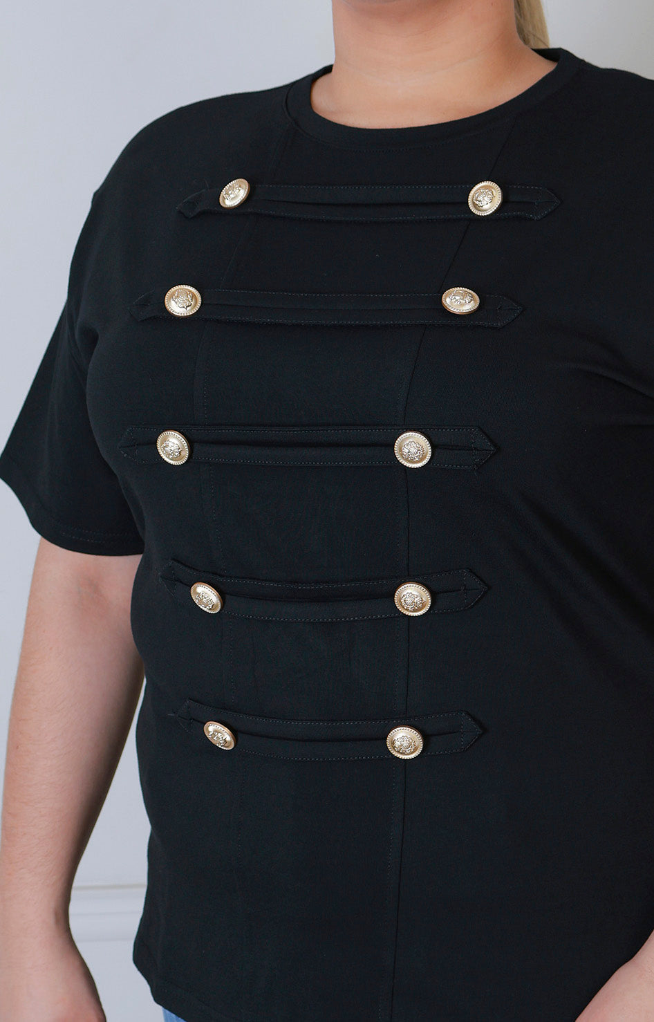 Blusa curva estilo militar con botones dorados, de la marca Boutiquemirel, en color oscuro y diseño elegante.