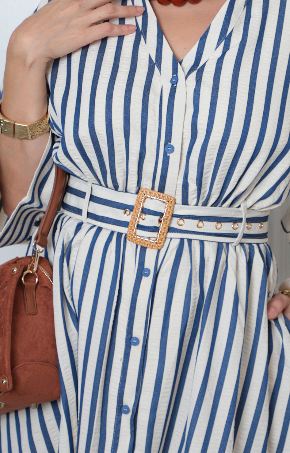 Vestido camisero corto a rayas con cinturón de la marca Boutiquemirel, con cuello y manga larga, en tonos azules y blancas.