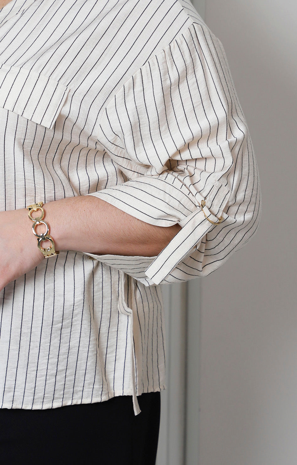 Blusa beige a rayas con detalle dorado