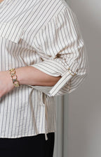 Blusa beige a rayas con detalle dorado