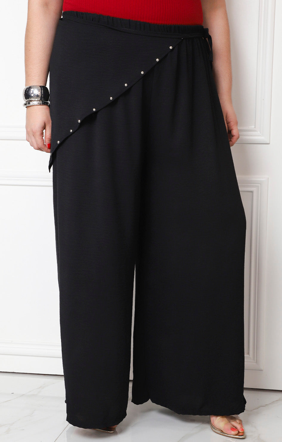 Pantalón asimétrico con aplicaciones de la marca Boutiquemirel, estilo curvy, en tela negra con detalles decorativos.