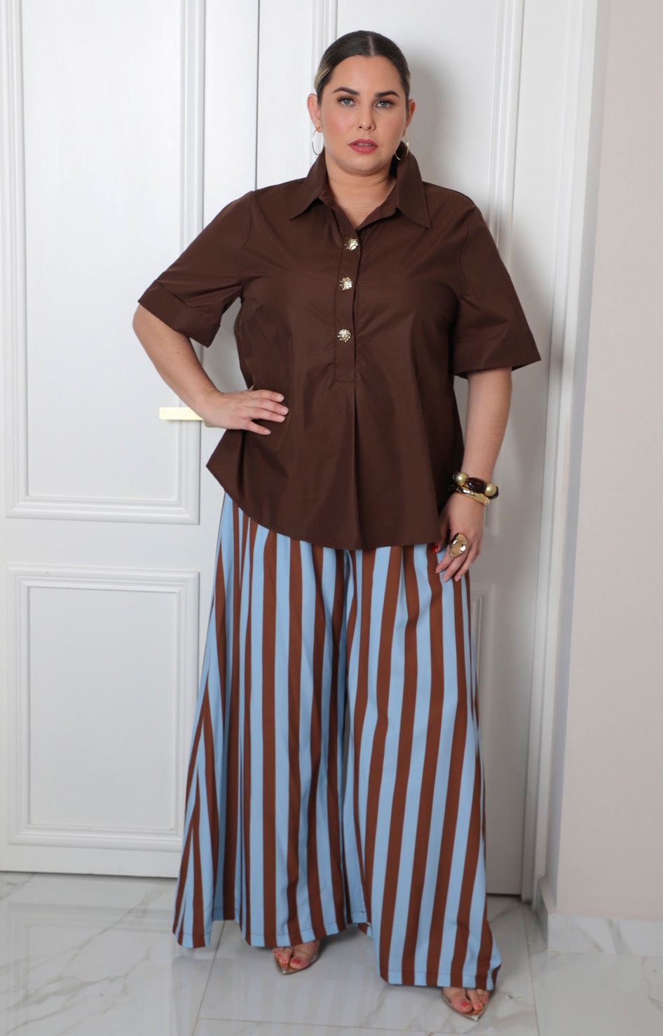 Blusa camisera curvy con botones dorados de la marca Boutiquemirel, con cuello y mangas largas, en color claro.