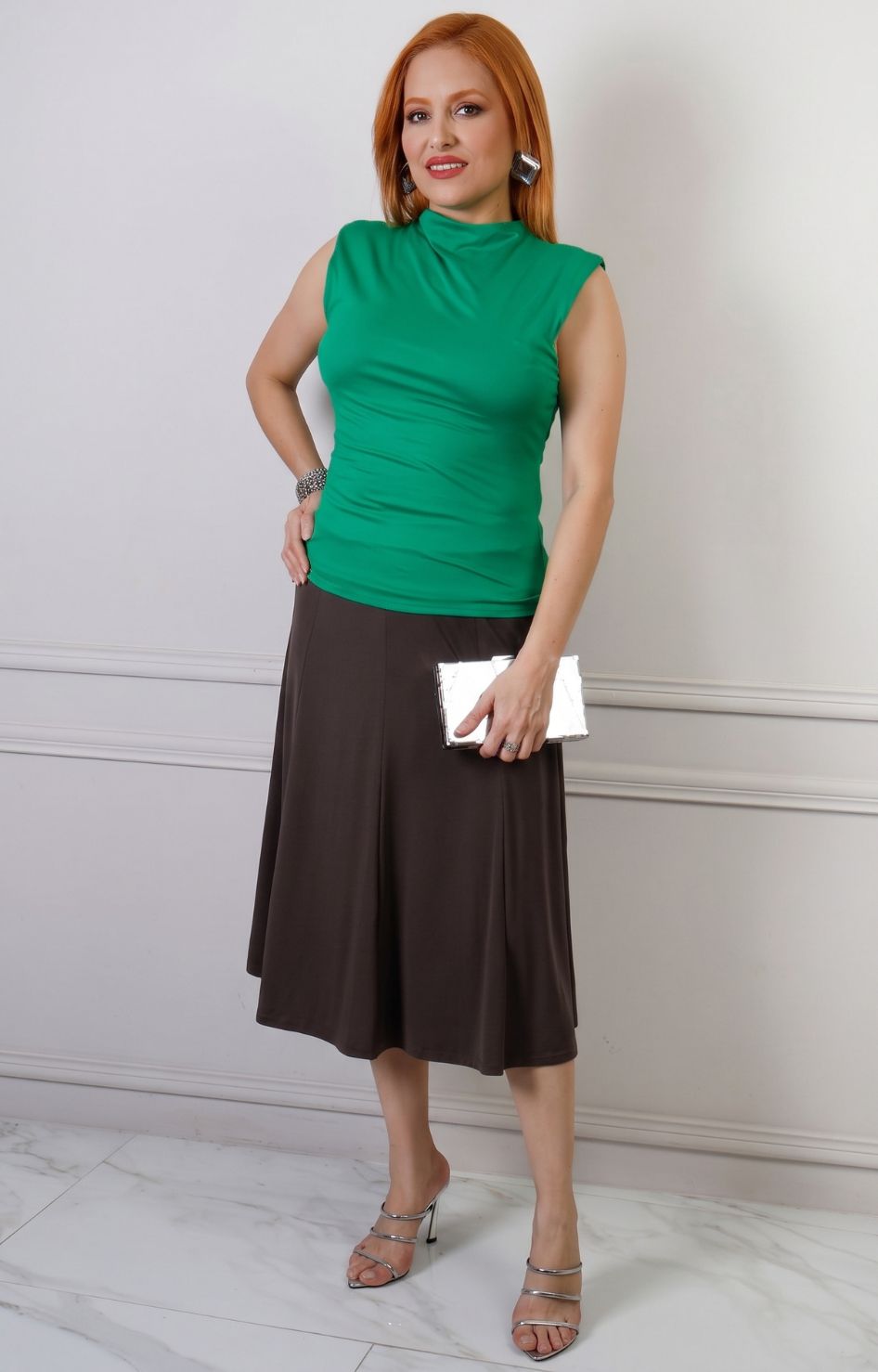 Falda midi regular con pretina elástica en color neutro, diseñada por Boutiquemirel, vista en ángulo lateral sobre fondo blanco.