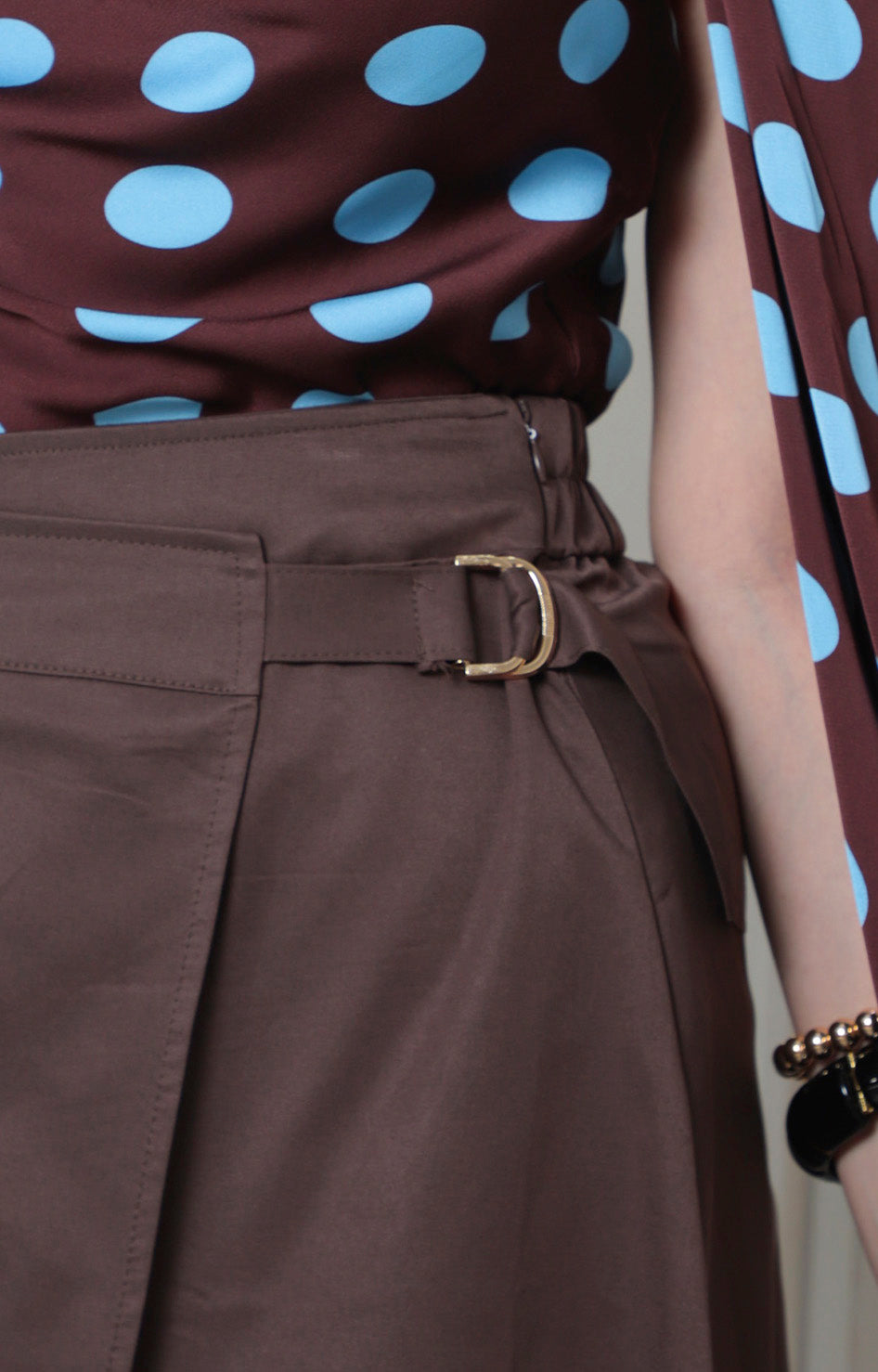 Falda larga asimétrica de Boutiquemirel con detalle dorado, diseño elegante y moderno, vista frontal en color oscuro