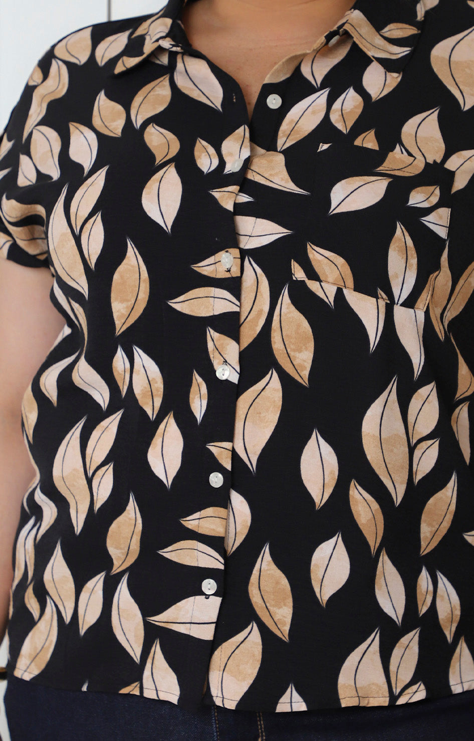 Blusa negra con estampado de hojas y botones
