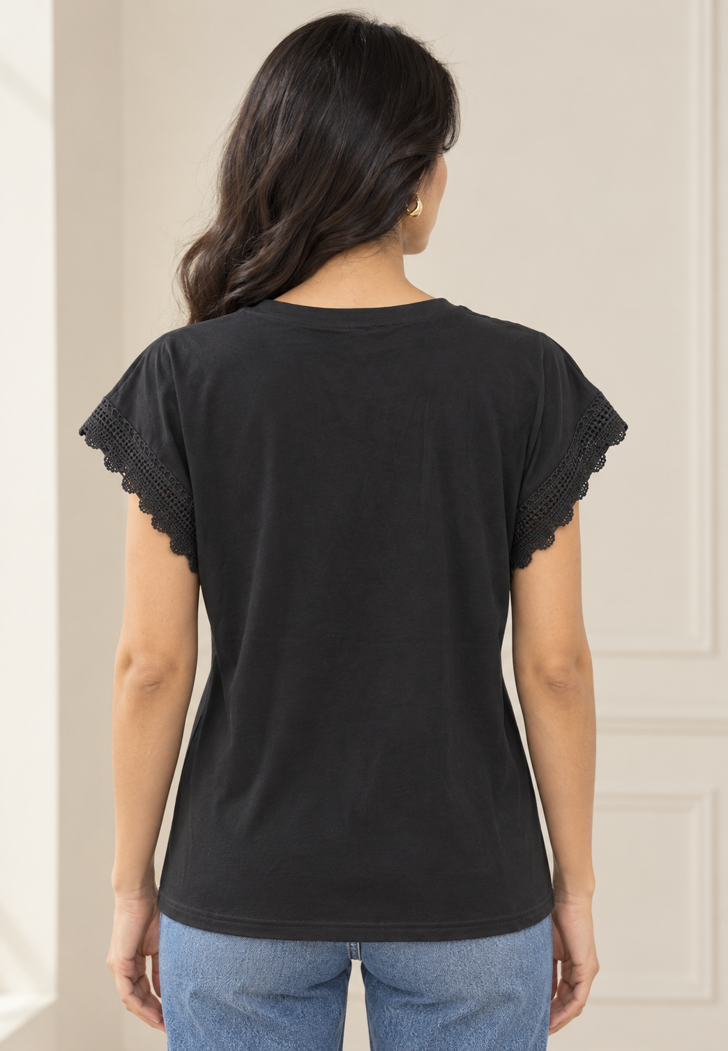 Blusa negra con flor plisada en hombro