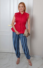 Blusa sin manga de Boutiquemirel con botones dorados, diseño elegante y moderno, vista frontal sobre fondo neutro.