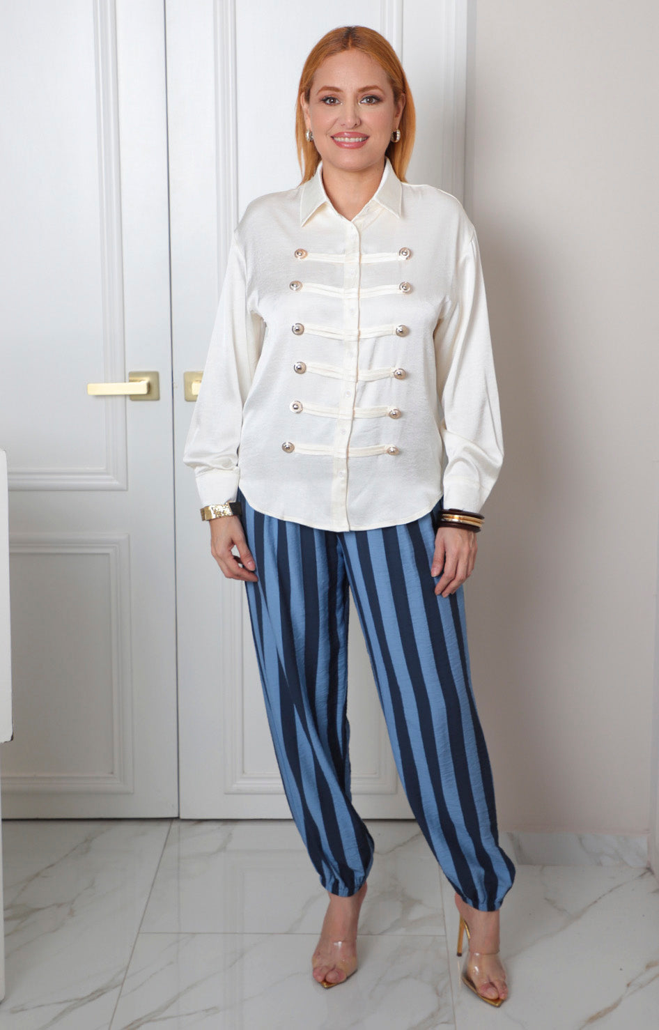 Camisa beige estilo militar con botones dorados, blusa regular de la marca Boutiquemirel, con cuello y manga larga.