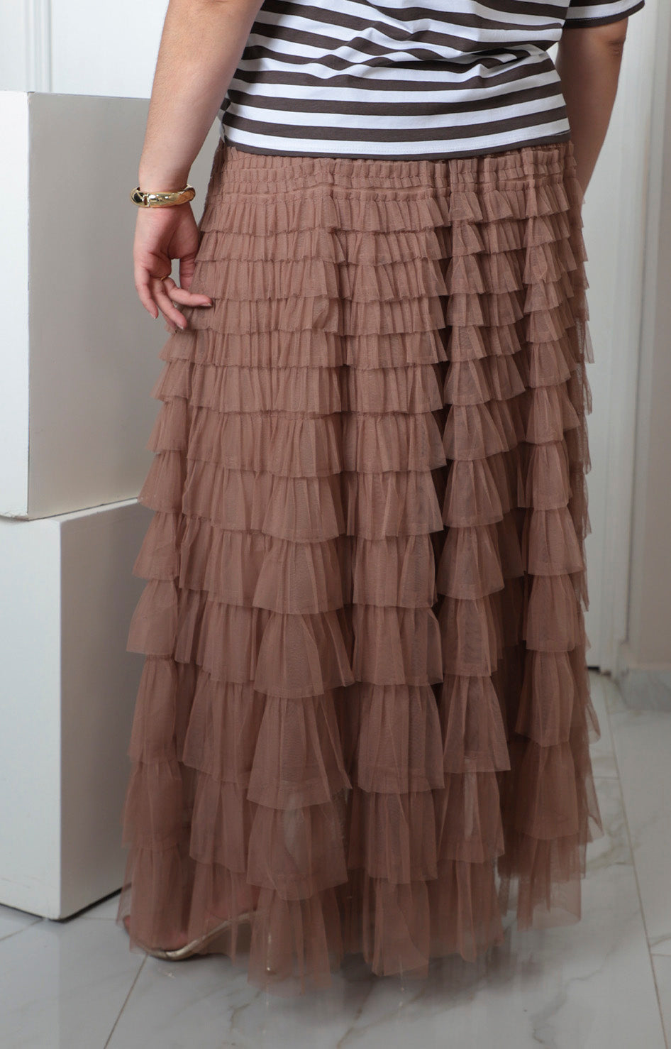 Falda curvy taupe en capas de Boutiquemirel, diseño elegante y favorecedor, sobre fondo neutro.
