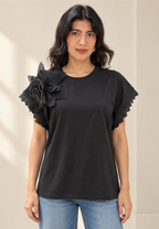 Blusa negra con flor plisada en hombro
