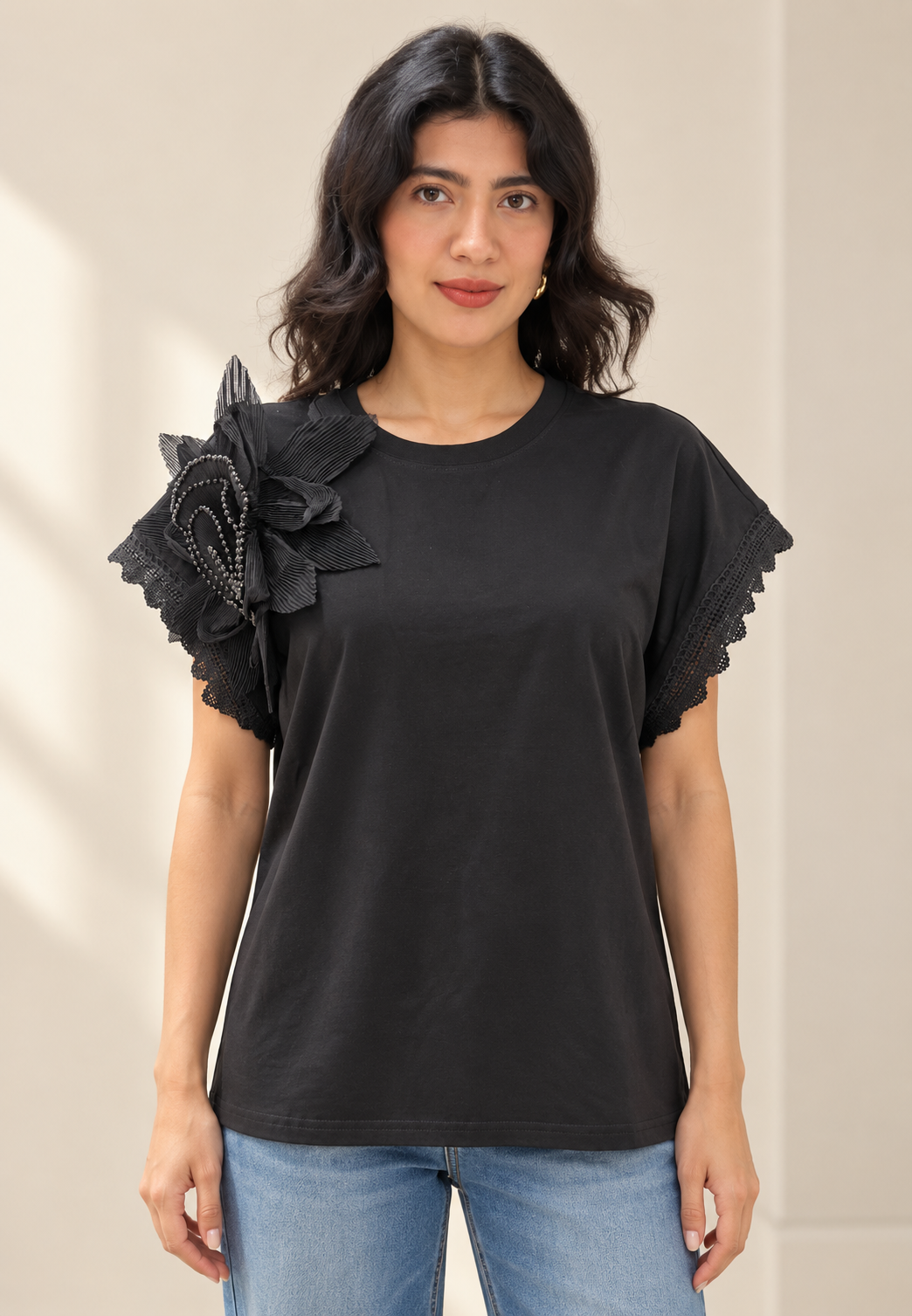 Blusa negra con flor plisada en hombro