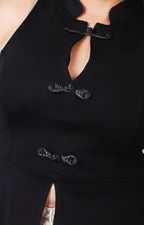 Blusa negra sin manga con broches orientales