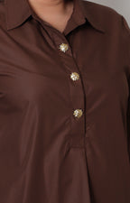 Blusa camisera curvy de Boutiquemirel con botones dorados, manga larga y diseño elegante en color neutro.