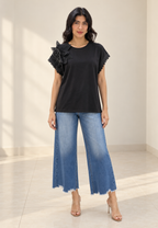 Blusa negra con flor plisada en hombro