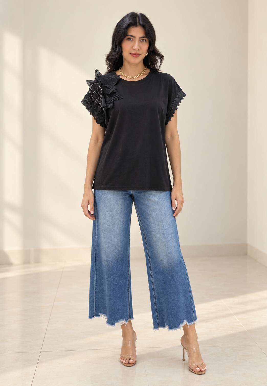 Blusa negra con flor plisada en hombro