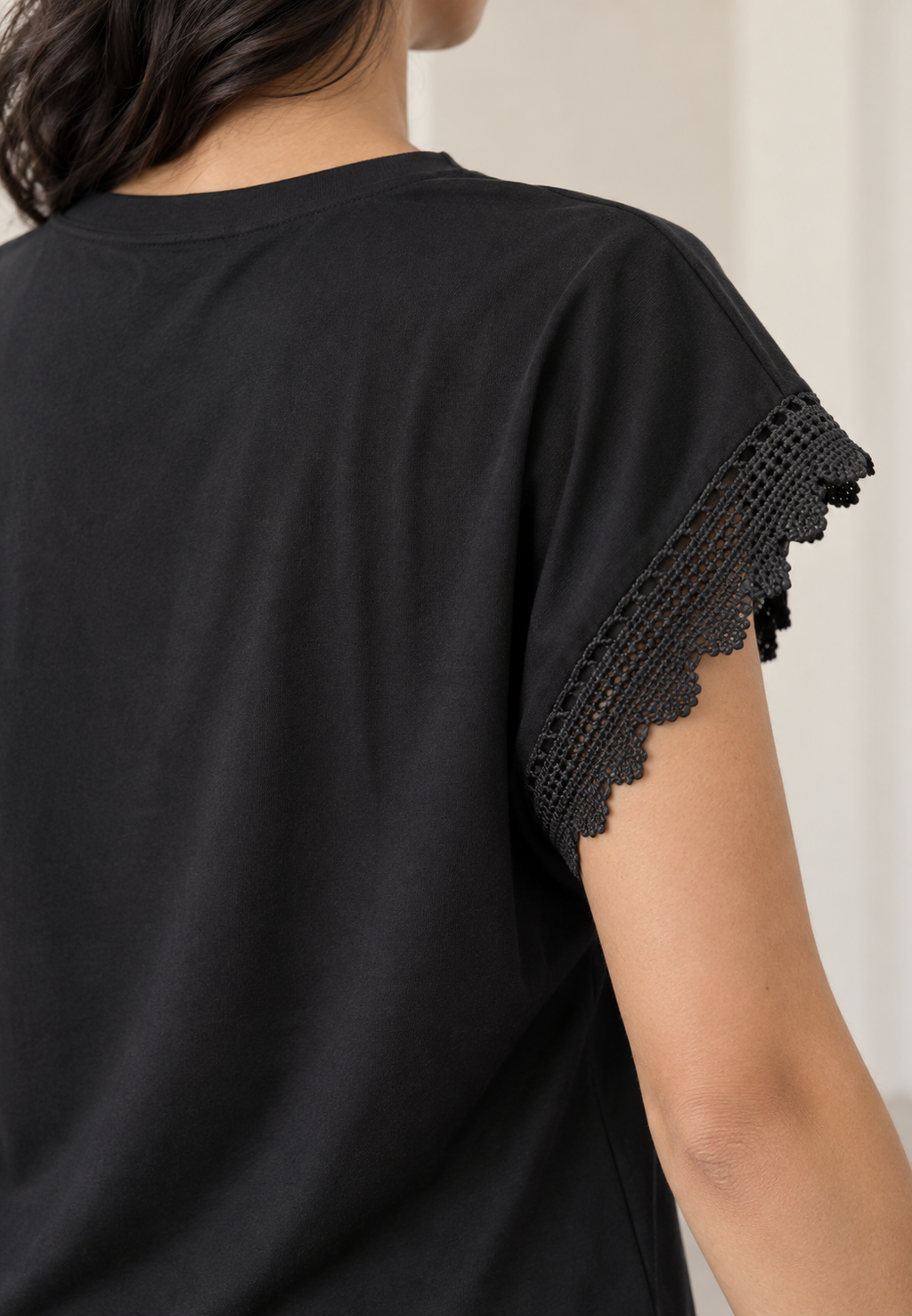 Blusa negra con flor plisada en hombro